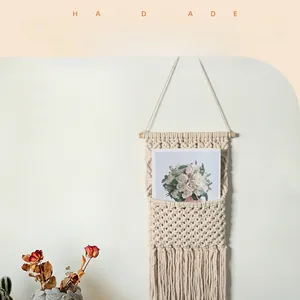 Detail of handmade bohemian woven wall hanging featuring a storage net and soft cotton tassels