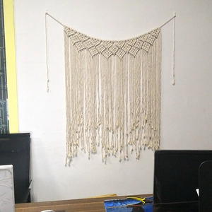 Handmade boho macrame wall hanging in cream cotton with geometric diamond weave and tassels
