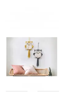 Detail of handcrafted bohemian macrame owl wall hanging with cotton tassels and wood