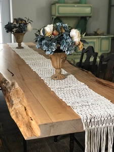 Detail of handmade macrame table runner featuring geometric patterns and fringe