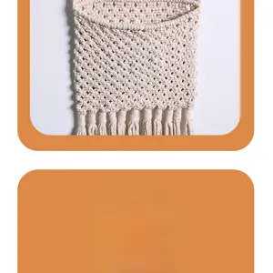 Close-up of bohemian hand-woven cotton macrame wall hanging storage bag with tassel fringe