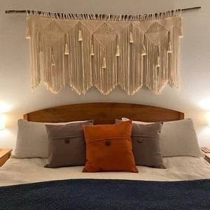 Detail of bohemian macramé wall hanging with woven geometric patterns and long tassels