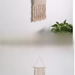 Close-up of bohemian macrame wall hanging with handmade cotton weave and wooden rod