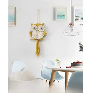 Detail of owl macrame wall hanging featuring yellow cotton rope and long tassels