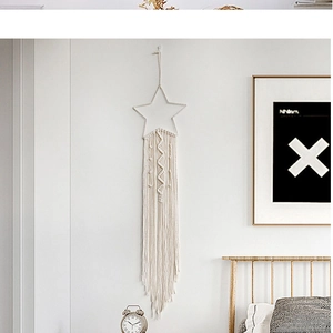 Detail eines handgefertigten Makramee-Stern-Traumfängers mit Baumwollquasten für Boho-Deko