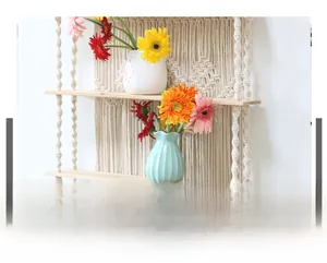 Detail of bohemian hand-woven cotton ropes and natural wood floating shelves