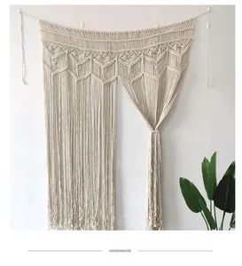 Détail d'une tenture murale en macramé tissée à la main avec motifs géométriques et franges