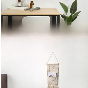 Detail of bohemian handmade cotton rope wall hanging tapestry with storage pocket and tassels