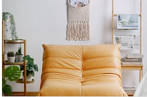 Detail of a ginger yellow Togo-style sofa featuring premium faux leather and tufted texture