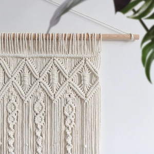 Bohemian handmade macrame wall hanging with geometric diamond patterns and cotton tassels