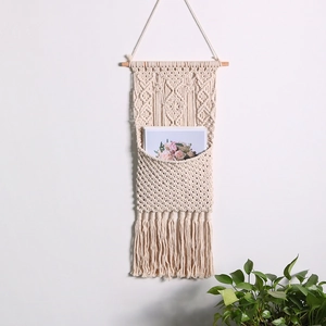 Handwoven bohemian wall hanging storage pocket in cream white cotton rope with tassels