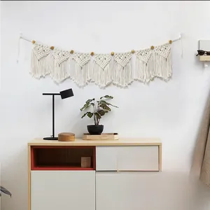 Detailed macro view of bohemian macrame wall hanging with hand-woven tassels and wood beads
