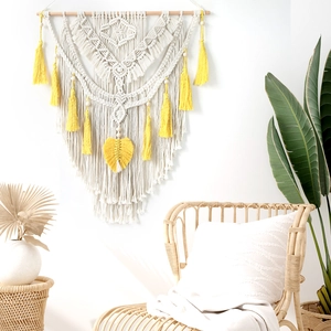 Detail of handmade boho macrame wall hanging with yellow fringe and cotton weaving