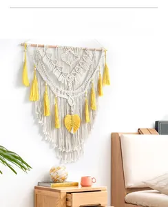 Detail view of Bohemian macrame wall hanging with yellow tassels and cotton weave texture