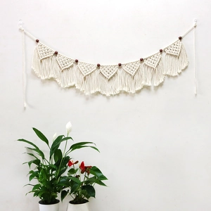 Detail of bohemian handmade woven wall hanging with cotton ropes and dark wooden beads