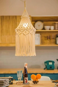 Detail of bohemian cream cotton macrame lampshade featuring fringe and geometric weaving