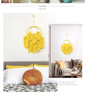 Détail de décoration murale en plumes macramé jaune dans chambre et salon cosy
