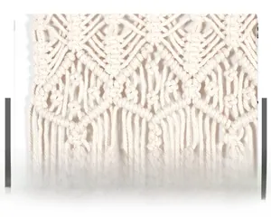 Macro detail of Nordic macrame wall hanging with diamond weave pattern and fringe tassels