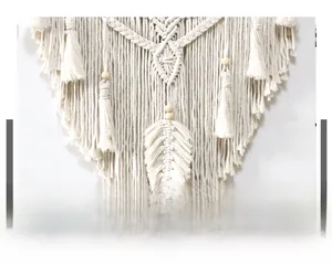 Detail of bohemian cotton woven tapestry with geometric knots and feather fringe