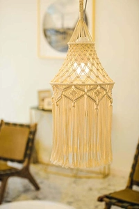 Detailed macro of bohemian macrame lamp shade featuring hand-woven knots and long fringe
