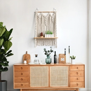 Detail of bohemian handmade cotton rope macrame shelf with wooden board and tassels