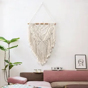 Macro detail of bohemian macramé wall hanging with intricate woven patterns and long tassels