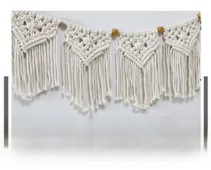 Detail of bohemian macrame wall hanging with cotton tassels and decorative wooden beads