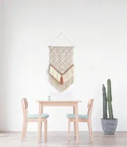 Détail d'une suspension murale bohème en macramé avec cordes de coton beige et glands