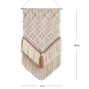 Détail d'une tenture murale en macramé bohème mesurant 45x80cm avec pompon rose
