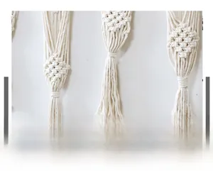 Macro view of handwoven cream cotton cord showing detailed diamond texture and long tassels