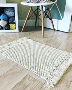Detailed macro view of woven beige cotton macrame table runner with decorative tassels