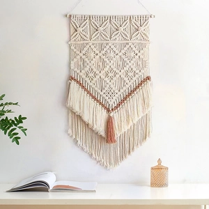 Détails des nœuds de macramé et des franges en coton brun-rouge de la tenture murale