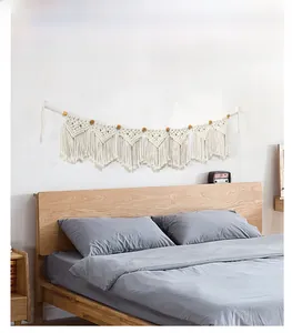 Close-up of Bohemian woven cotton tapestry with wood beads and fringe wall hanging detail