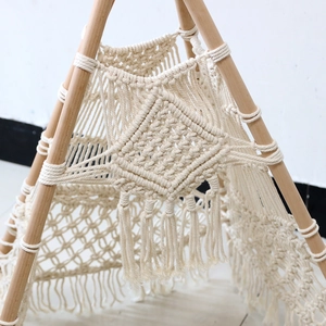 Close-up of handmade macramé cotton rope weave and boho tassels on a pet tent