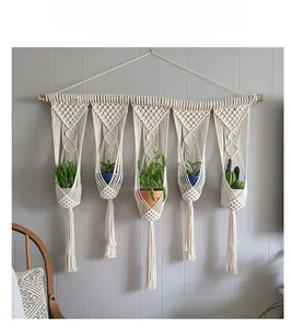 Detail of macrame plant hanger with five tasseled pockets and natural wooden beam