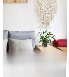 Detail of bohemian handmade woven cotton wall hanging tapestry with fringe and geometric textures
