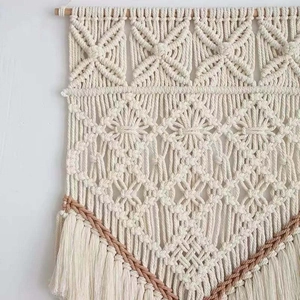 Gros plan de tapisserie bohème tissée main avec motifs géométriques et franges en coton