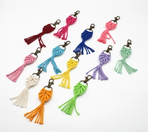 Close-up of handmade bohemian leaf fringe keychains in eleven vibrant cotton colors