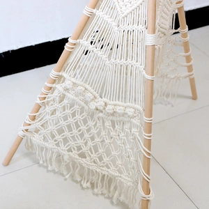 Detailed close-up of Nordic woven cotton rope tapestry with handmade macrame patterns and tassels