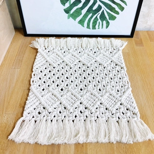 Handmade boho cotton woven table runner with tassel accents on a light wooden table