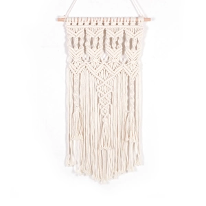 Handmade Bohemian macrame wall hanging featuring natural cotton rope and elegant tassels
