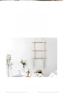 Detail of bohemian handmade cotton woven tapestry wall hanging with fringe and wooden bars