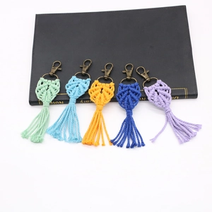 Detail of five handmade bohemian macrame leaf keychains with fringe in vibrant colors