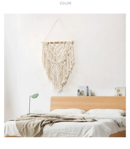 Close-up of Bohemian hand-woven macrame wall hanging with cotton tassels in a cozy bedroom