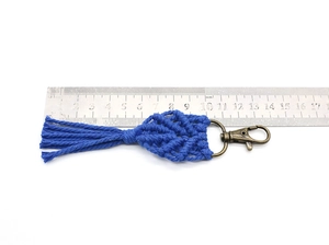 Detailed measurement of dark blue macrame leaf keychain with dimensions shown on a steel ruler