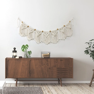 Boho woven cotton wall hanging with 7 textured tassels and wooden beads on white wall
