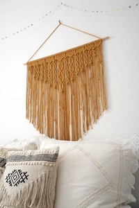 Nahaufnahme eines senfgelben handgewebten Makramee-Wandteppichs im Boho-Stil mit Fransen
