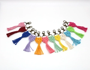 Detail showing 12 colors of handmade macrame leaf keychains with bronze metal clasps
