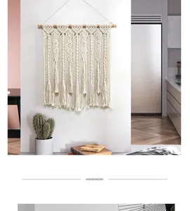 Détail d'une tenture murale bohème en coton tissé main avec motifs géométriques et longs franges