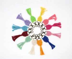 Top view of handmade macrame leaf keychains in 12 vibrant colors on white background